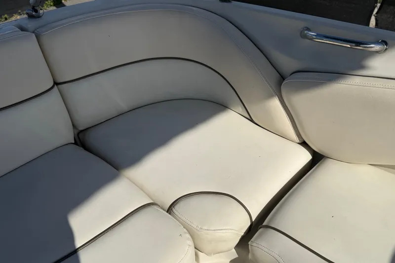 Slide: The Image of 2008 Sea Ray 240 Sundeck boat interior with white cushioned seating. - 78