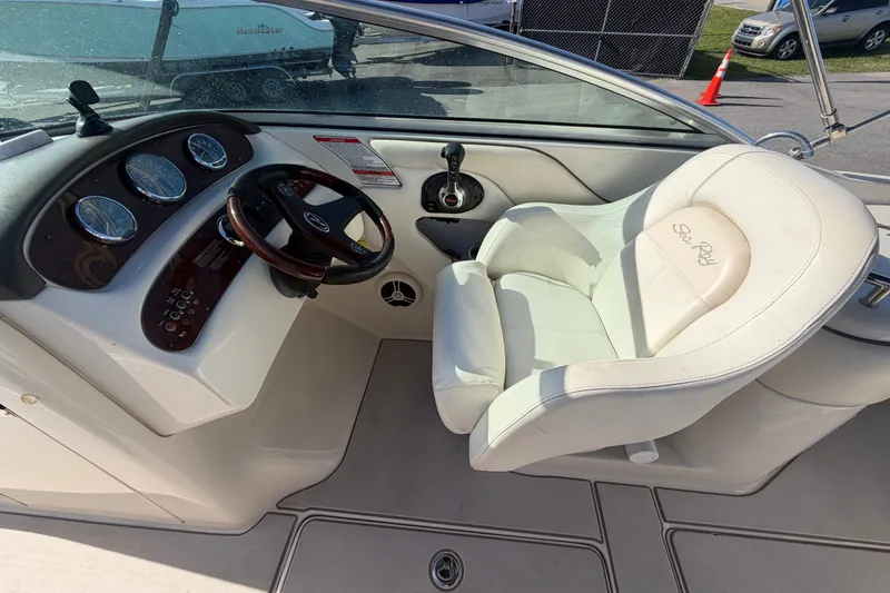 Slide: The Image of 2008 Sea Ray 240 Sundeck cockpit with steering wheel and white captain's chair. - 39