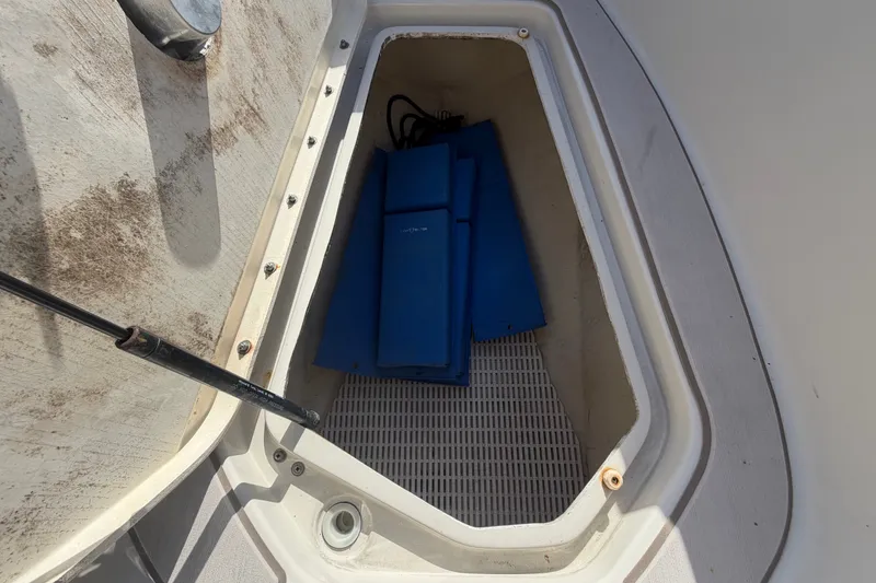 Slide: The Image of Storage compartment of 2008 Sea Ray 240 Sundeck with blue accessories inside. - 56