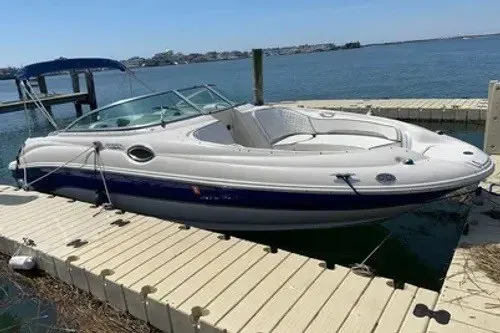 The Image of 2008 Sea Ray 240 Sundeck boat docked by the water on a sunny day. - 2