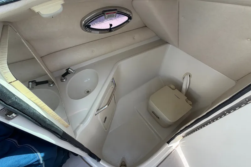 Slide: The Image of Interior of 2008 Sea Ray 240 Sundeck boat bathroom with sink and portable toilet. - 36