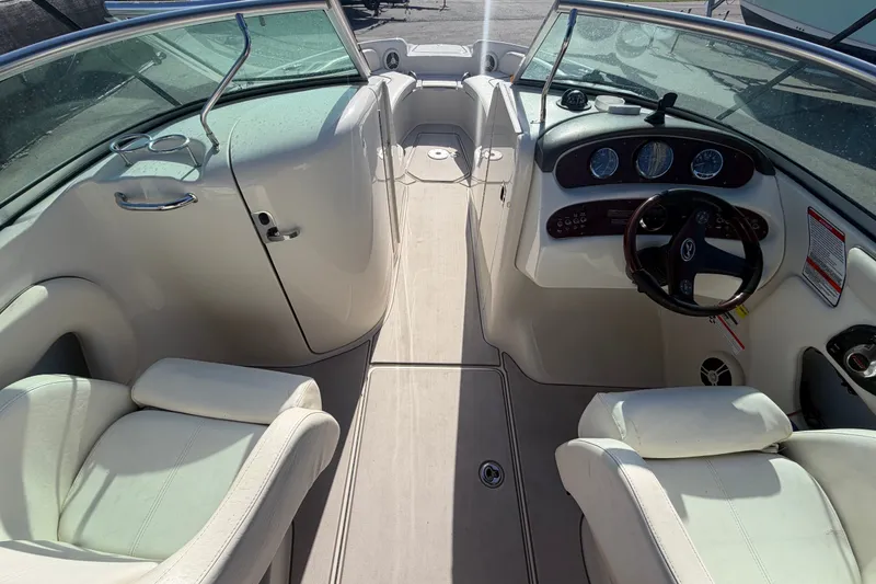 Slide: The Image of Interior view of a 2008 Sea Ray 240 Sundeck boat, featuring white seating and dashboard. - 32
