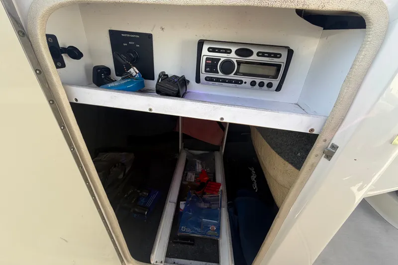 Slide: The Image of Storage compartment of a 2008 Sea Ray 240 Sundeck with stereo and ignition controls. - 49