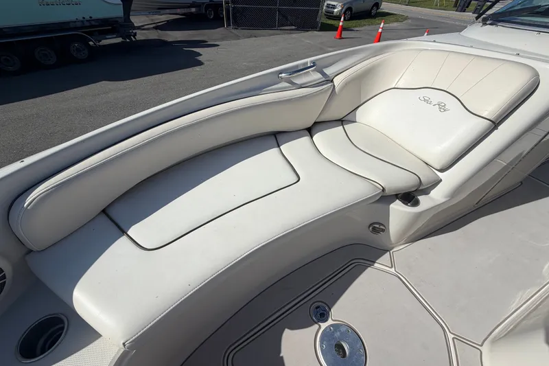 Slide: The Image of 2008 Sea Ray 240 Sundeck boat with white cushioned seating and cup holders. - 66