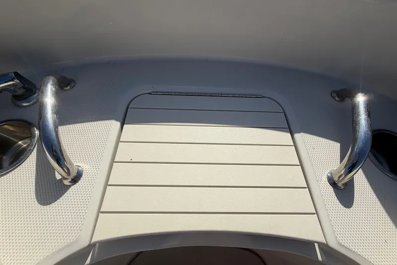 Slide: The Image of 2008 Sea Ray 240 Sundeck boat deck with stainless steel handles and textured flooring. - 60