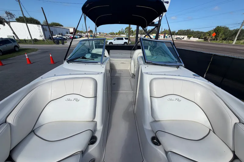 Slide: The Image of 2008 Sea Ray 240 Sundeck boat with white seating and windshield, parked outdoors. - 70