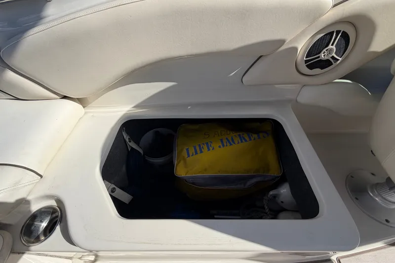 Slide: The Image of Storage compartment on a 2008 Sea Ray 240 Sundeck with life jackets inside. - 76