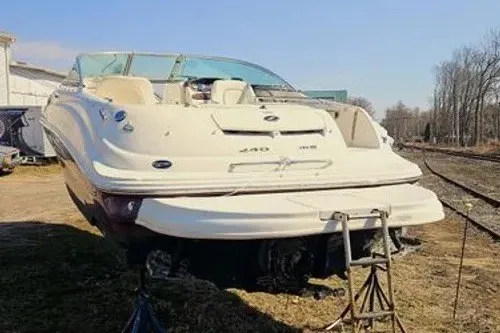 Slide: The Image of 2008 Sea Ray 240 Sundeck boat on stands, outdoors, with clear sky background. - 1