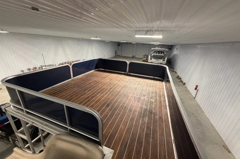 Slide: The Image of 2014 South Bay 526 CRUDS TRIPLE pontoon boat in a spacious indoor storage facility. - 15