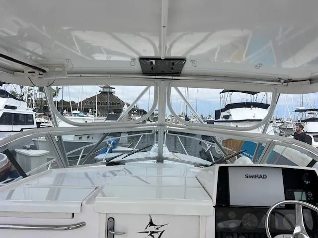 Slide: The Image of 1997 Blackfin 30.7 EXPRESS boat interior view at marina, featuring Simrad navigation system. - 11