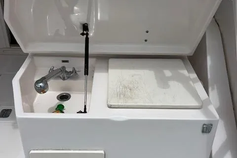Slide: The Image of 1997 Blackfin 30.7 EXPRESS boat sink and cutting board setup. - 18