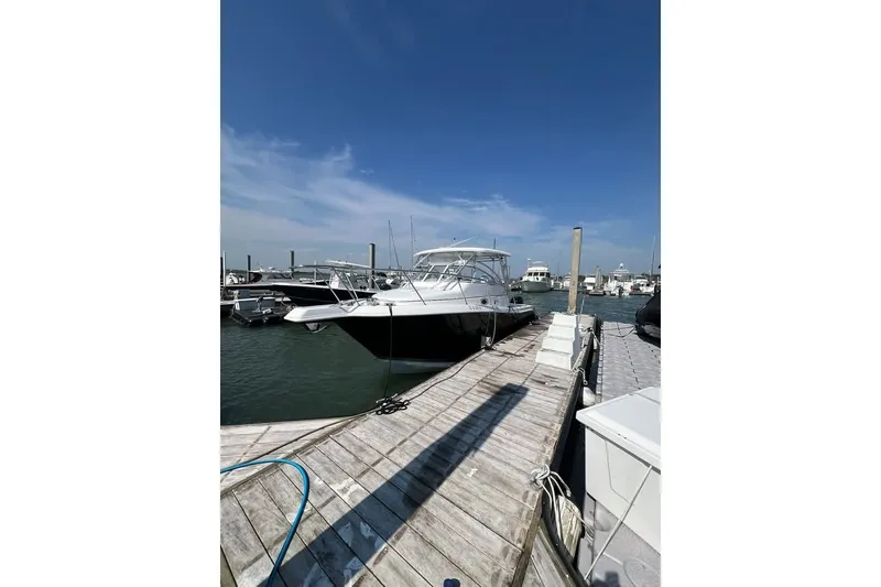 Slide: The Image of 2006 Pro-Line 28 Express boat docked at marina under clear blue sky. - 4