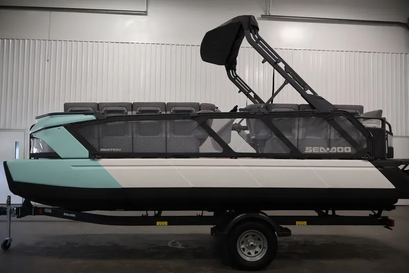 Slide: The Image of 2027 Sea-Doo Switch Cruise 21 pontoon boat in a showroom, side view. - 15
