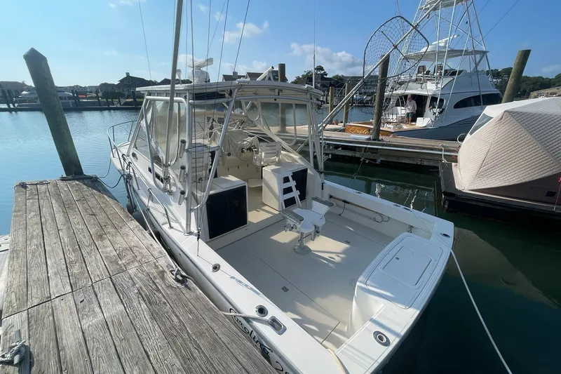 Slide: The Image of 2004 Carolina Classic 28 boat docked at marina under clear blue sky. - 2