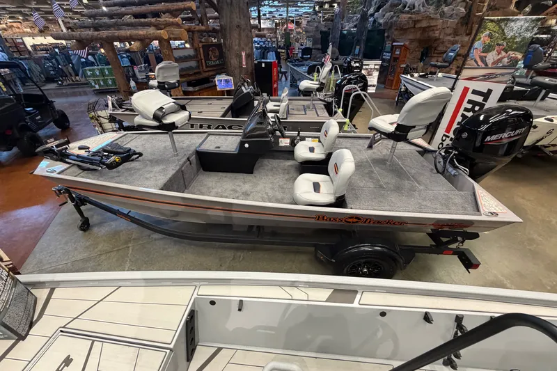 Slide: The Image of 2027 Tracker Bass Tracker Classic Limited boat displayed indoors, featuring seating and fishing equipment. - 34