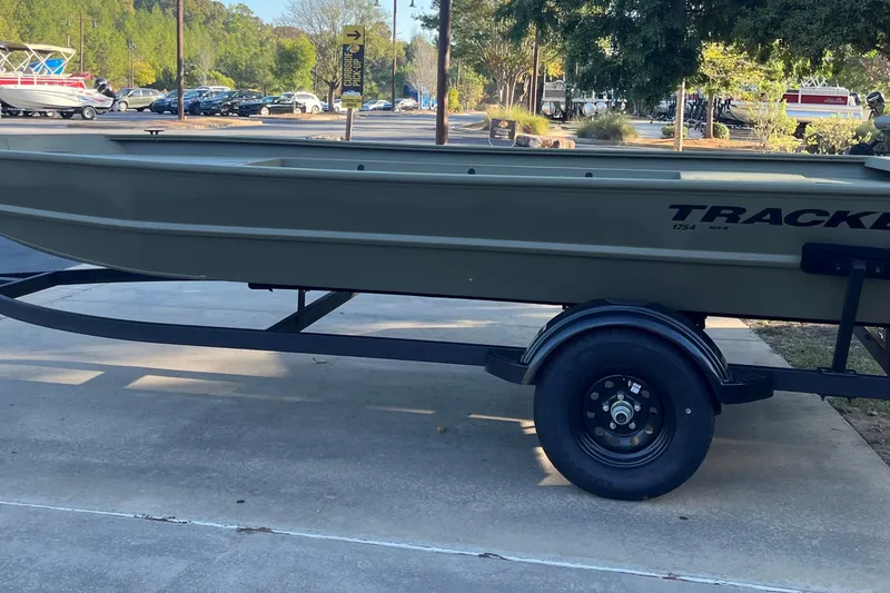 The Image of 2027 Tracker Grizzly 1754 Utility boat on trailer, parked outdoors. - 0