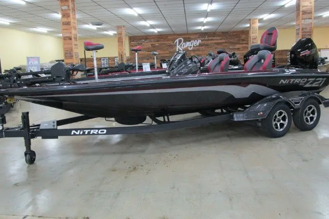 Slide: The Image of 2026 Nitro Z21 XL Pro bass boat on display in showroom with trailer. - 3