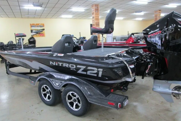 Slide: The Image of 2026 Nitro Z21 XL Pro boat in showroom, featuring sleek design and dual axle trailer. - 1