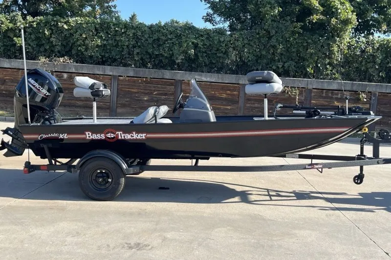 The Image of 2027 Tracker Bass Tracker Classic XL fishing boat on trailer, parked outdoors. - 0