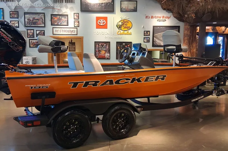 The Image of 2027 Tracker Pro Team 195 boat displayed indoors with vibrant orange design. - 0