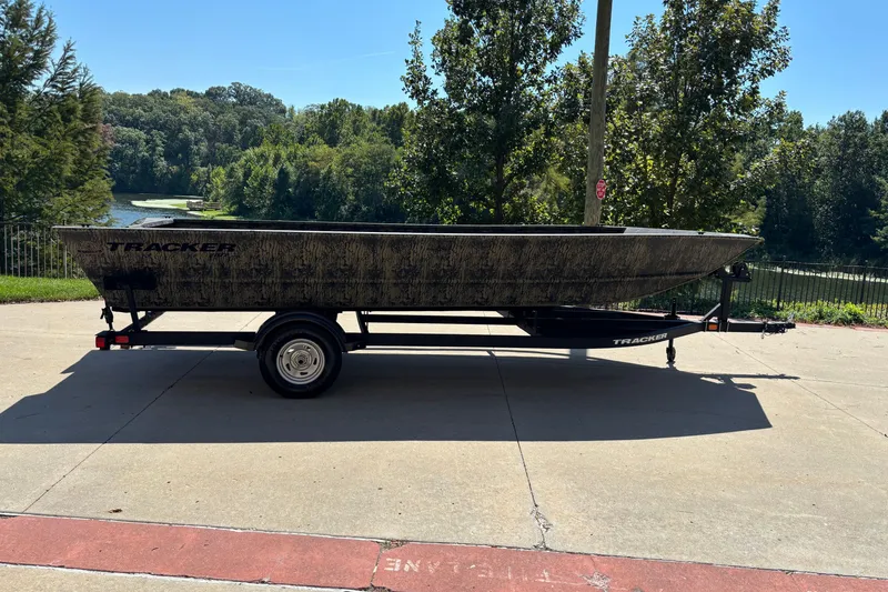 The Image of 2026 Tracker Grizzly 2072 Utility boat on trailer, parked near a scenic lake. - 0