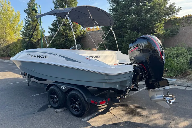Slide: The Image of 2027 Tahoe 1950 boat with Mercury Pro XS engine on trailer in parking lot. - 1