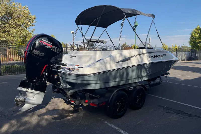 Slide: The Image of 2027 Tahoe 1950 boat with Mercury 150 engine, parked outdoors. - 5