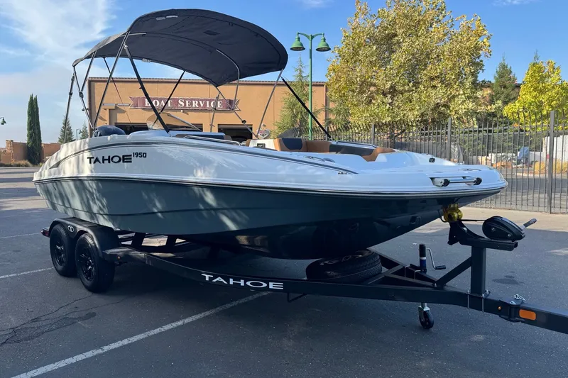 Slide: The Image of 2027 Tahoe 1950 boat on trailer, parked outdoors near service center. - 3