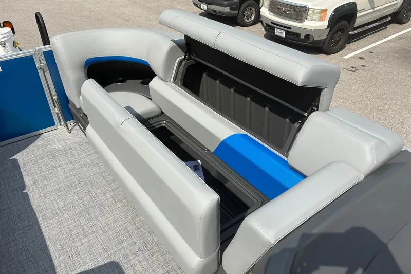Slide: The Image of 2027 Sun Tracker Party Barge 20 DLX with open storage compartments and gray seating. - 13