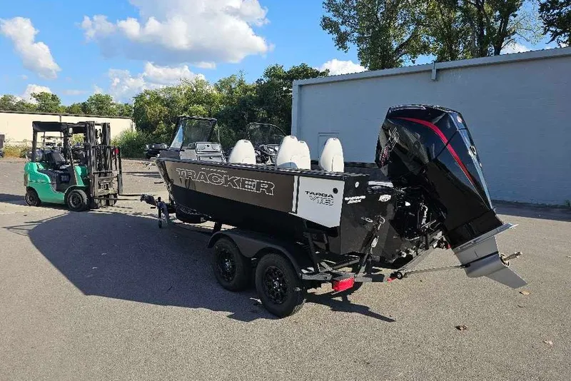 Slide: The Image of 2027 Tracker Targa V-18 Combo boat on trailer, parked outdoors with forklift nearby. - 45