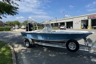 Slide: The Image of 2026 Mako 18 Pro Skiff boat on trailer, parked outdoors near a building. - 3