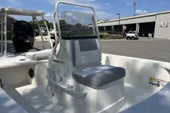 Slide: The Image of 2026 Mako 18 Pro Skiff boat interior with seating and console, parked outdoors. - 4