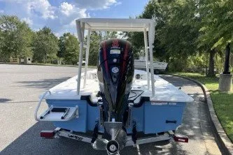 Slide: The Image of 2026 Mako 18 Pro Skiff boat with outboard motor, parked on a sunny day. - 7
