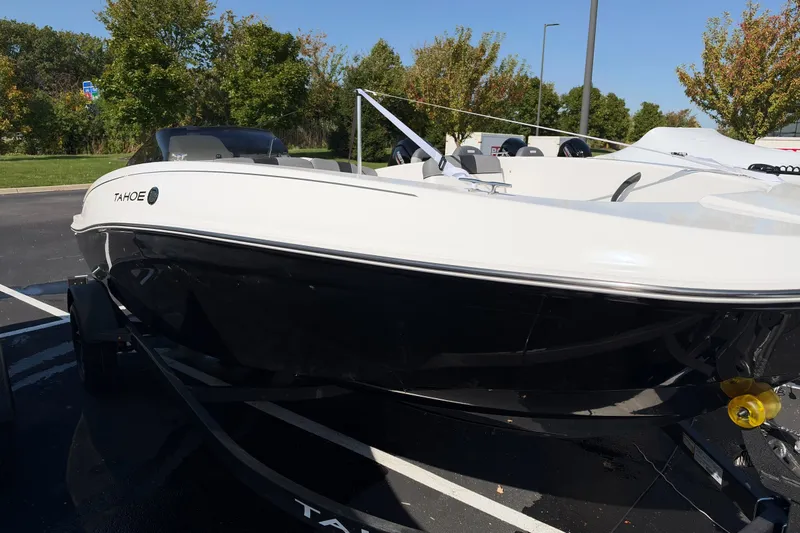 Slide: The Image of 2027 Tahoe T18 boat in parking lot, sleek design, black and white exterior. - 2