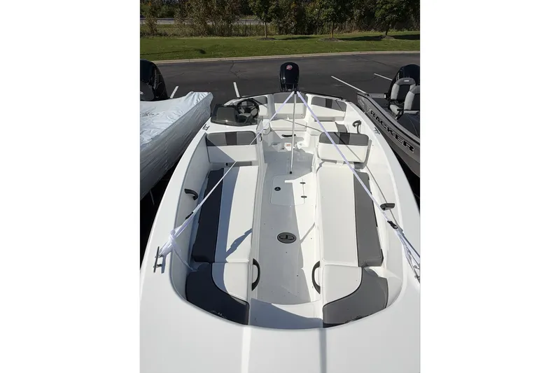 Slide: The Image of 2027 Tahoe T18 boat with sleek white design and spacious seating, parked outdoors. - 3