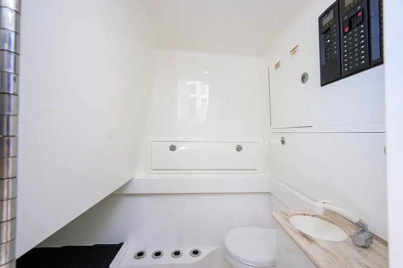Slide: The Image of 2021 Valhalla V-41 boat interior with compact bathroom, featuring sink, toilet, and control panels. - 73