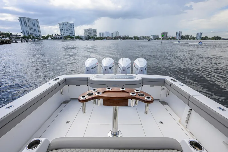 Slide: The Image of 2021 Valhalla V-41 boat with quad engines on a calm waterway, city skyline in background. - 23
