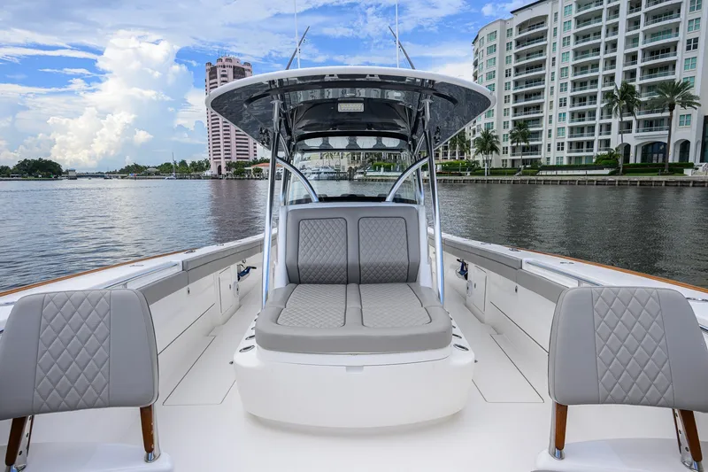 Slide: The Image of 2021 Valhalla V-41 boat interior with luxurious seating, docked near waterfront buildings. - 56