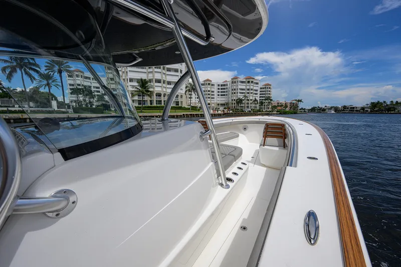 Slide: The Image of 2021 Valhalla V-41 boat docked near luxury waterfront apartments, under a clear blue sky. - 47