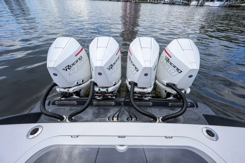 Slide: The Image of Four powerful outboard engines on a 2021 Valhalla V-41 boat, docked on calm water. - 20