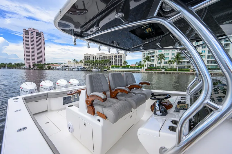 Slide: The Image of 2021 Valhalla V-41 boat interior with luxurious seating and modern controls, docked near waterfront buildings. - 37