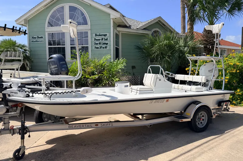 The Image of 2022 Beavertail Skiffs Mosquito 18' boat on trailer, parked near a green building. - 0