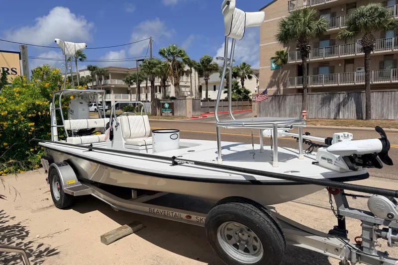 Slide: The Image of 2022 Beavertail Skiffs Mosquito 18' boat on trailer, parked near palm trees and buildings. - 1