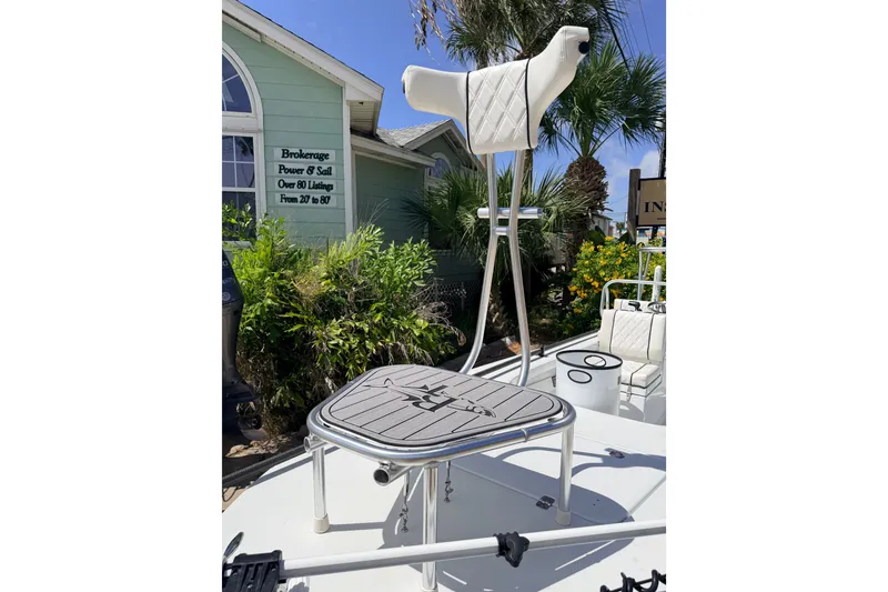 Slide: The Image of 2022 Beavertail Skiffs Mosquito 18' boat with elevated seat, docked near greenery. - 28