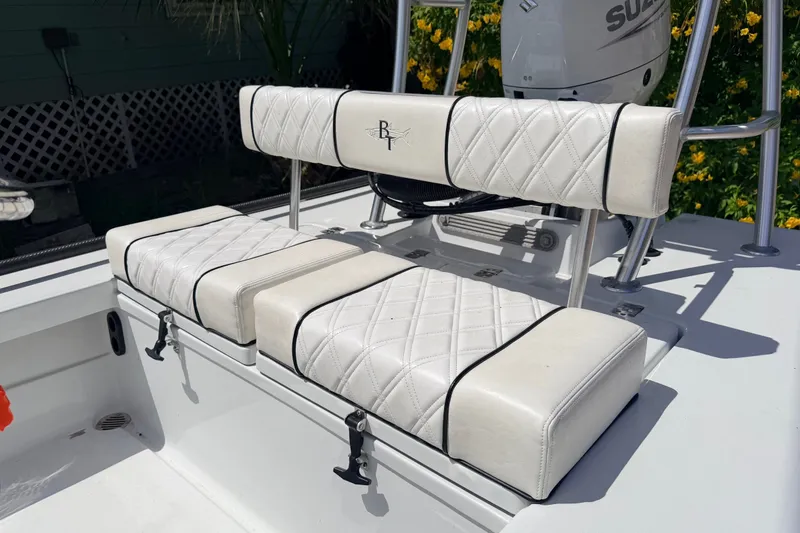 Slide: The Image of 2022 Beavertail Skiffs Mosquito 18' boat seating with diamond-stitched upholstery and Suzuki motor. - 17