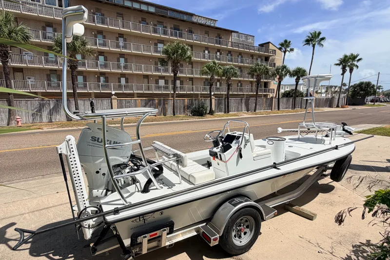 Slide: The Image of 2022 Beavertail Skiffs Mosquito 18' boat on trailer, parked near palm trees and buildings. - 3