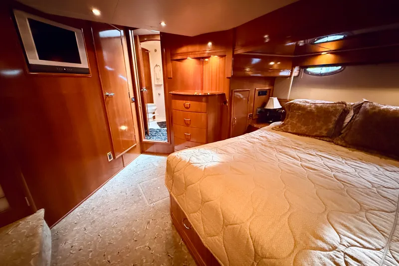 Slide: The Image of Luxurious 2005 Carver 56 Voyager yacht bedroom with elegant wood finishes and cozy bedding. - 39