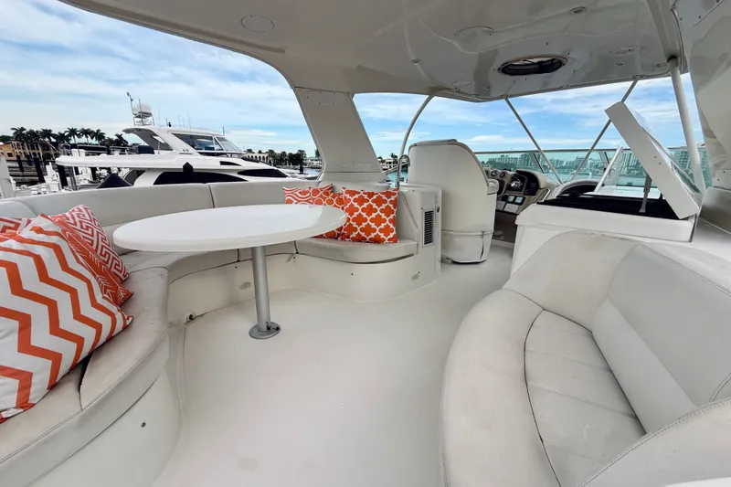 Slide: The Image of Luxurious 2005 Carver 56 Voyager yacht interior with seating, table, and vibrant cushions. - 59