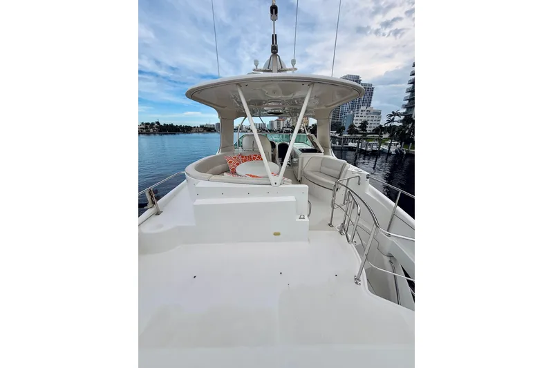 Slide: The Image of 2005 Carver 56 Voyager yacht deck with seating, overlooking marina and cityscape. - 56