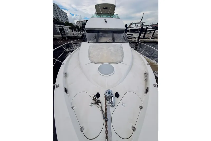 Slide: The Image of 2005 Carver 56 Voyager yacht docked at marina, showcasing sleek design and spacious deck. - 18